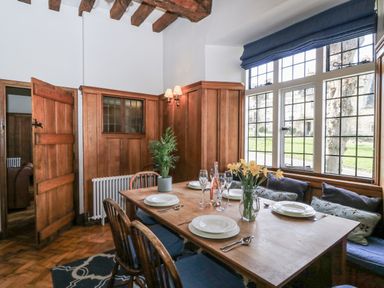 A dining room with a table and chairs at Ostlers in Burford