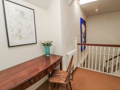 A hallway with a desk and map at Ostlers in Burford