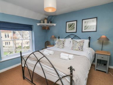 A bedroom with a bed and nightstand at Ostlers in Burford