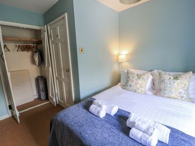 A bedroom with a bed and wardrobe at Ostlers Burford