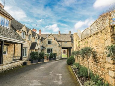 An outdoor area with stone buildings and plants at Ostlers Burford