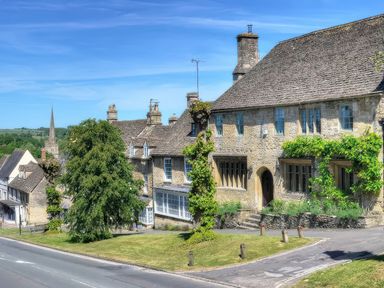 A building with a tree and road at Ostlers in Burford