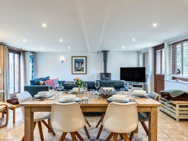A dining room with a table set for dinner at Woodyplatt in Marhamchurch