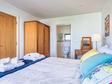 A bedroom with a bed and wardrobe at Chapel Park in Marhamchurch