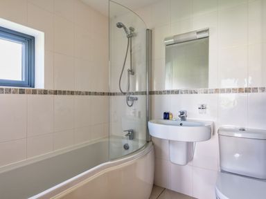 A bathroom with a bathtub, shower, sink, and toilet at Little Main in Marhamchurch