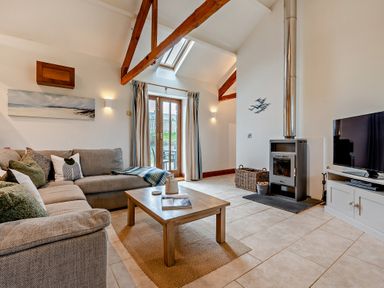 A living room with a sofa and coffee table at Long Down Spa in Marhamchurch