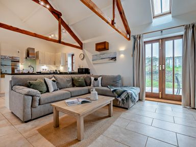 A living room with a sofa and coffee table at Long Down Spa in Marhamchurch