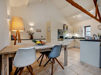 A kitchen with a dining table and chairs at Long Down Spa in Marhamchurch