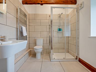 A bathroom with a shower, sink, and toilet at Long Down Spa in Marhamchurch