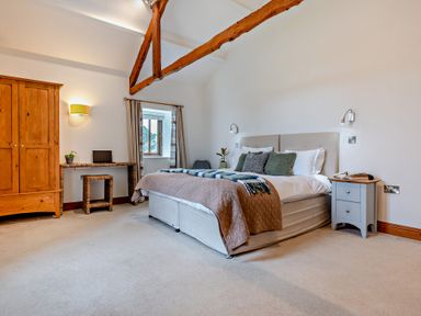 A bedroom with a bed and a wardrobe at Long Down Spa in Marhamchurch
