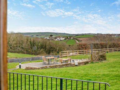 An outdoor seating area with a table and chairs at Middle Hill in Marhamchurch