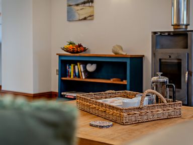 A living room with a basket and bookshelves at Middle Hill Marhamchurch