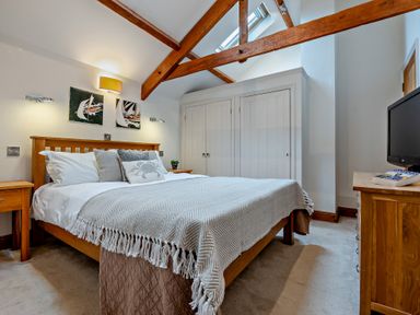 A bedroom with a bed and nightstands at Middle Hill in Marhamchurch