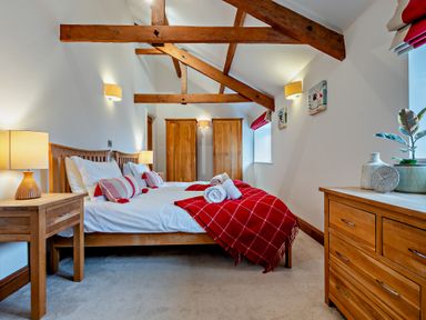 A bedroom with a bed and wooden furniture at Middle Hill in Marhamchurch