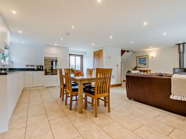 A dining room with a table and chairs at Sand Parks in Marhamchurch