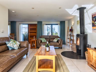 A living room with a fireplace and seating at Venners in Marhamchurch
