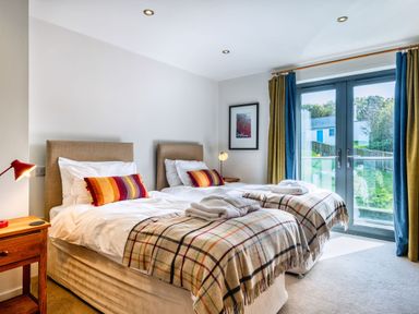 A bedroom with two beds and a window at Venners in Marhamchurch