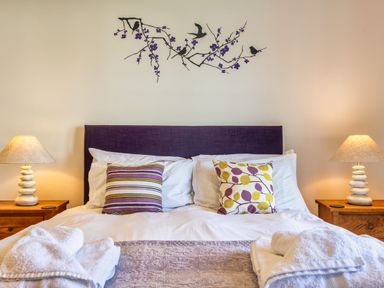 A bedroom with a bed and decorative accessories at Venners in Marhamchurch