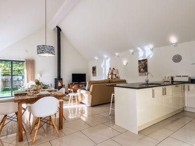 A living room with a sofa and dining area at Warrens Spa in Marhamchurch