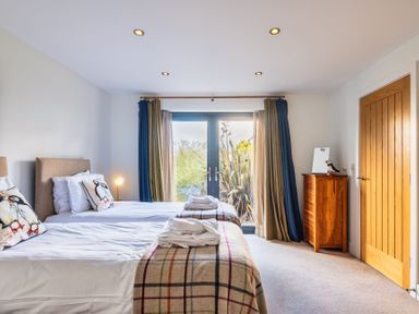 A bedroom with two beds and a wooden dresser at Warrens Spa Marhamchurch