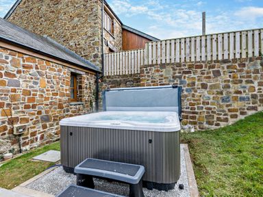 A hot tub with steps in an outdoor area at Warrens Spa in Marhamchurch