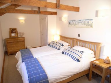 A bedroom with twin beds and wooden furniture at Westcotts in Marhamchurch
