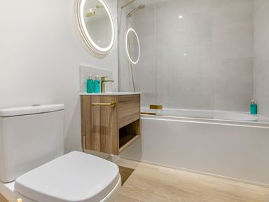 A bathroom with a toilet, bathtub, and a sink at Gwari Spa Barn 2.0 in Marhamchurch