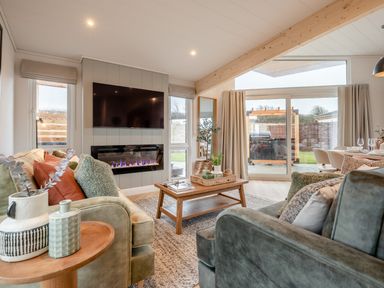 A living room with a sofa and a coffee table at Trelowen 2.0 Spa Marhamchurch