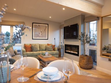 A living room with a sofa, coffee table, and television at Trelowen 2.0 Spa in Marhamchurch