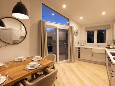A kitchen with a table and chairs at Trelowen 2.0 Spa in Marhamchurch