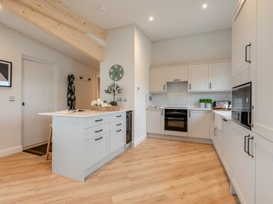 A kitchen with cabinets, island, and appliances at Trelowen 2.0 Spa in Marhamchurch
