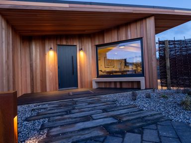An outdoor entrance with a wooden door and window at Trelowen 2.0 Spa Marhamchurch