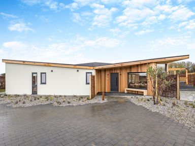 A modern house with a pathway and garden at Trelowen 2.0 Spa in Marhamchurch