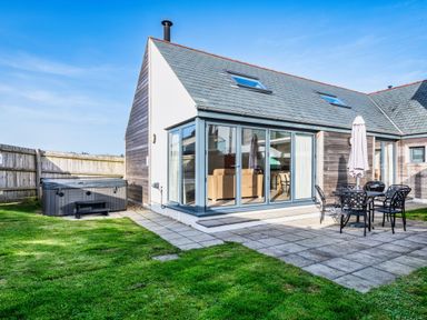 An outdoor area with a hot tub and seating at Nettlecoombe Spa in Marhamchurch