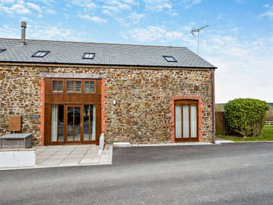A stone building with windows and doors at Jack's House in Marhamchurch