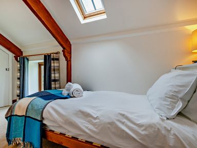 A bedroom with a bed and towels at Jack's House in Marhamchurch