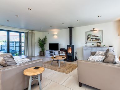 A living room with a fireplace and television at Arundell in Marhamchurch