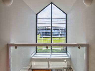 A staircase with a window and handrail at Arundell in Marhamchurch