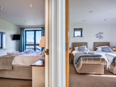A bedroom with two beds and a television at Arundell in Marhamchurch
