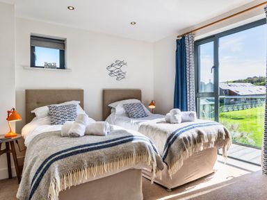 A bedroom with two beds and a view at Arundell in Marhamchurch