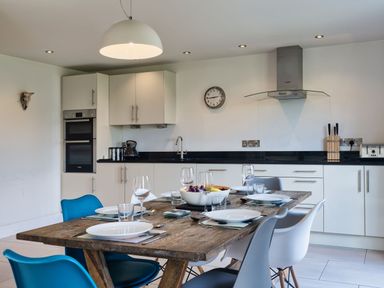A kitchen with a dining table set at Eagle's Nest in Marhamchurch