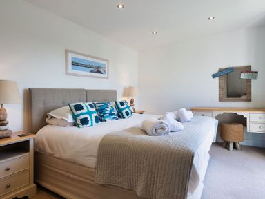 A bedroom with a bed and a desk at Eagle's Nest in Marhamchurch