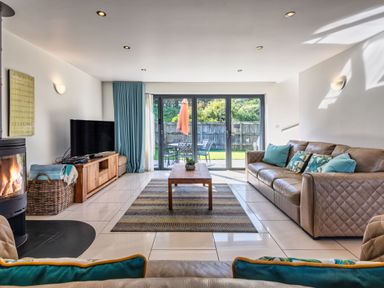 A living room with a sofa, coffee table and television at Sheep's House in Marhamchurch