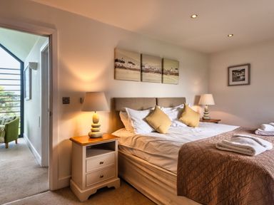 A bedroom with a bed and bedside table at Trevelyan in Marhamchurch