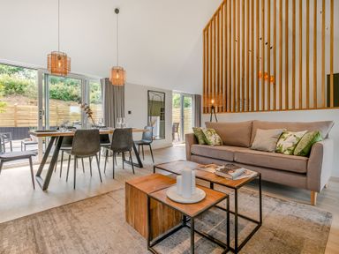 A living room with a sofa and dining table at Gwari Spa Barn 3.0 in Marhamchurch