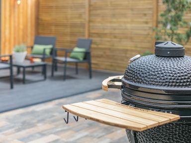 A grill with a table and chairs in the garden at Gwari Spa Barn 3.0 Marhamchurch