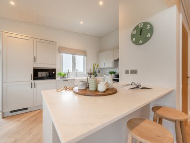 A kitchen with a countertop and stools at Trelowen 3.0 Spa in Marhamchurch