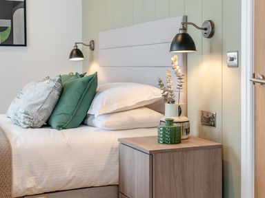 A bedroom with a bed and bedside table at Trelowen 3.0 Spa Marhamchurch