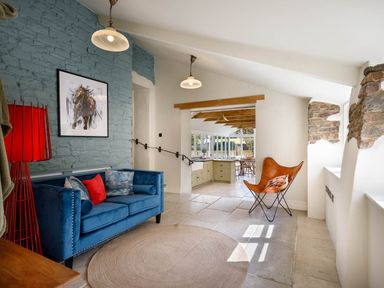 A living room with a sofa and artwork at Whalesborough Farmhouse Spa in Marhamchurch