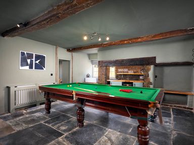 A game room with a pool table and bar area at Whalesborough Farmhouse Spa in Marhamchurch